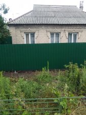 Кривой забор из профнастила в Донецке относительно дома